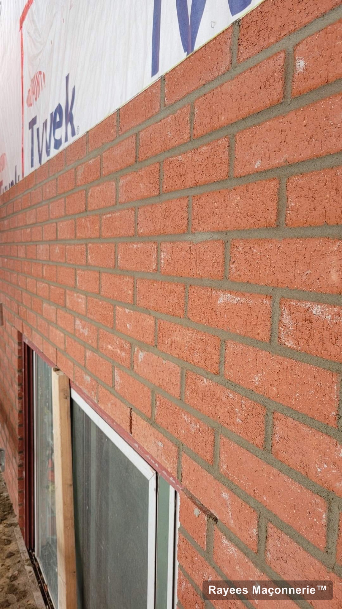 Mur de brique rouge neuf autour d’une fenêtre